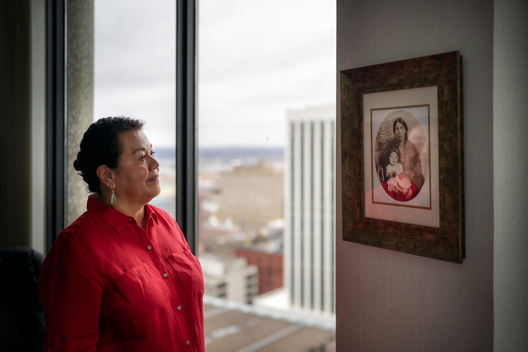 Juliet Rudie looks at a portrait of her great great grandmother holding her grandmother.