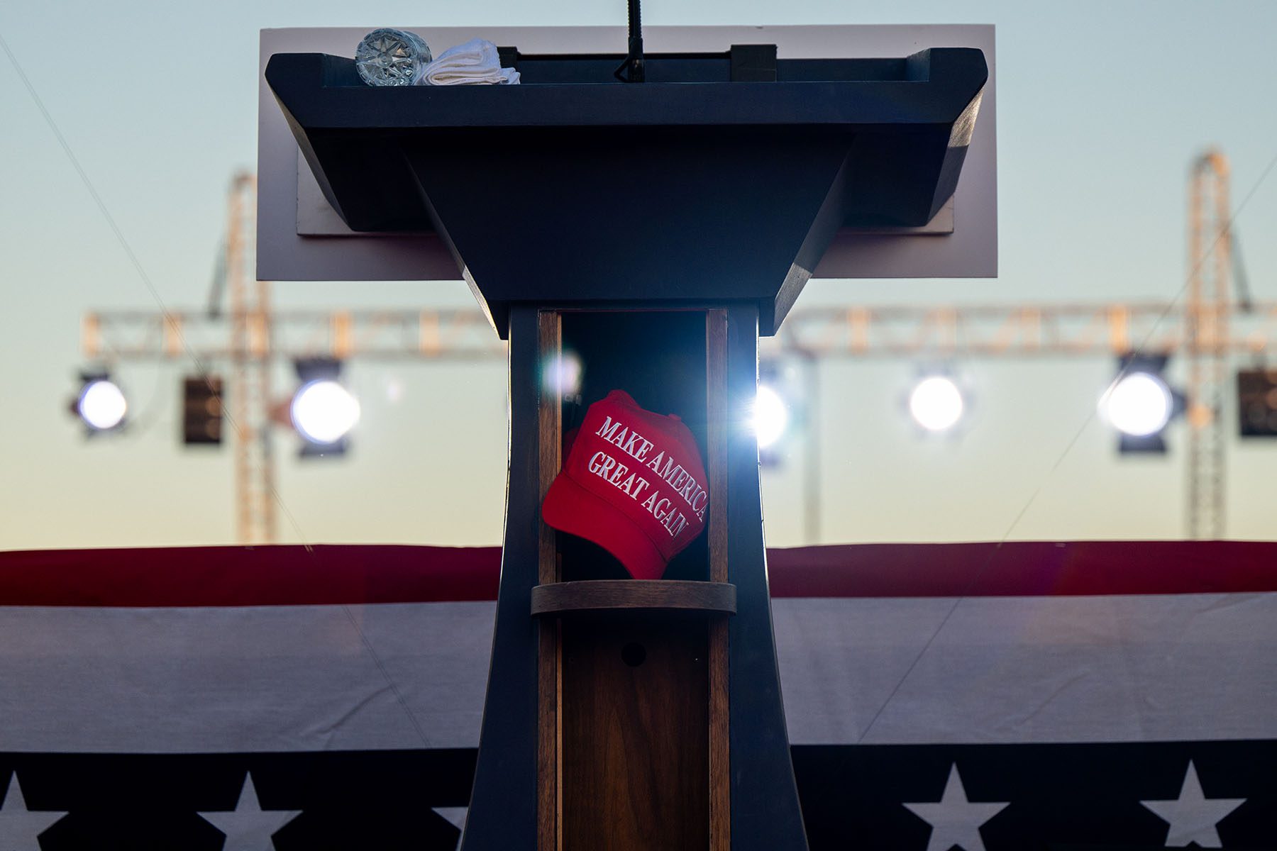 Former President Donald Trump's baseball cap is seen left in a podium at the conclusion of a rally