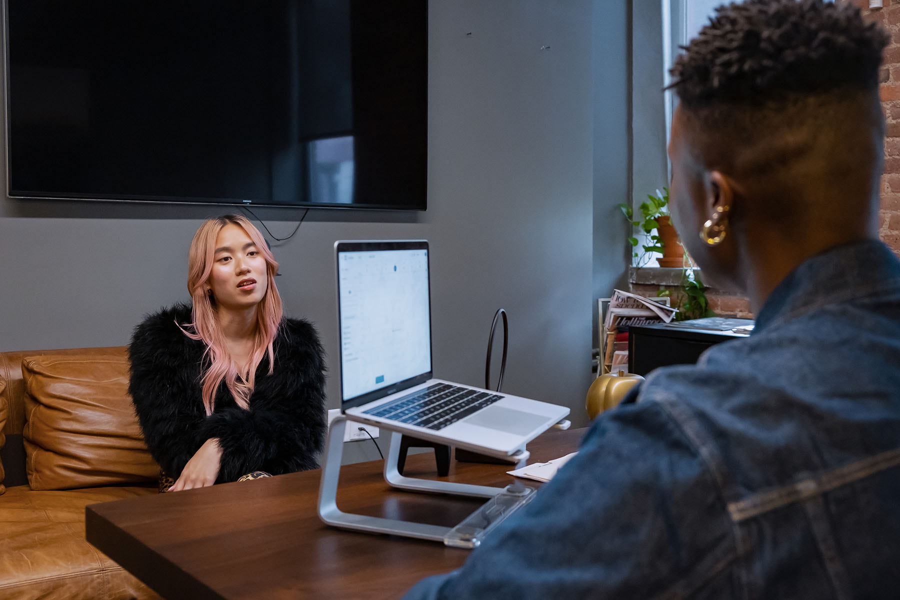 A transfeminine person speaks to a therapist in an office.