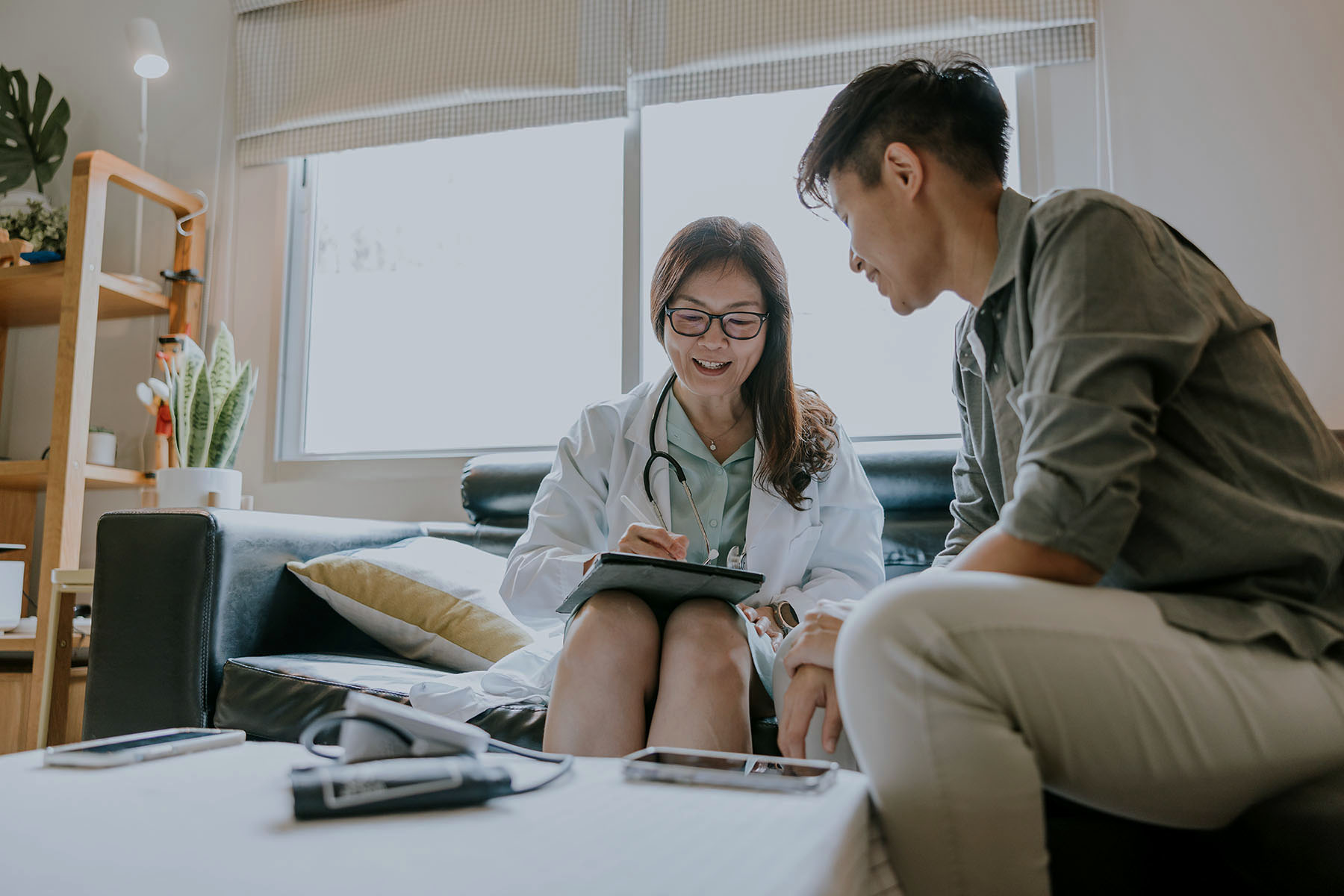 Asian doctor talking and giving an advice to a transgender patient after surgery.