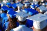 Graduates viewed from behind wearing graduation caps and gowns.