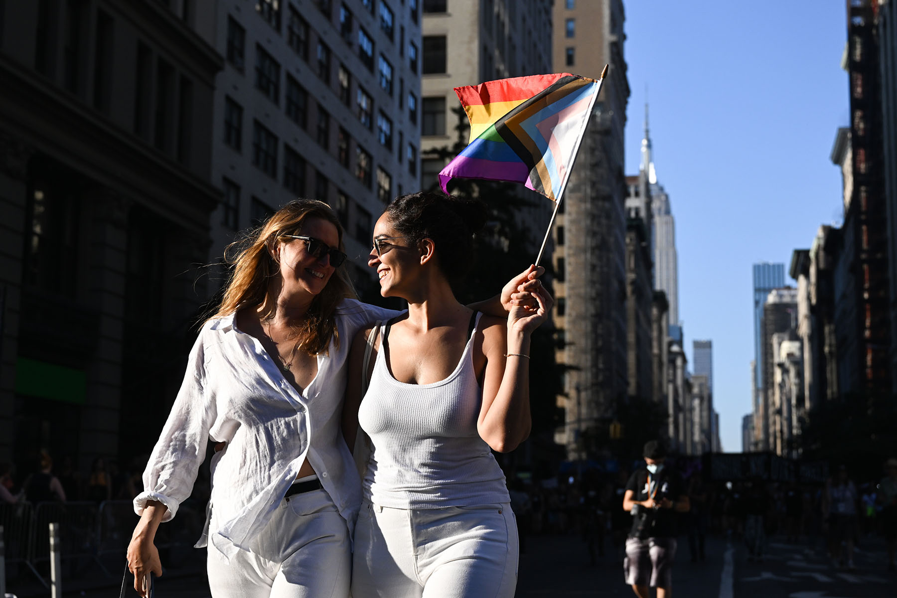 Two women waving a Pride flag participate in the 30th Annual New York City Dyke March.