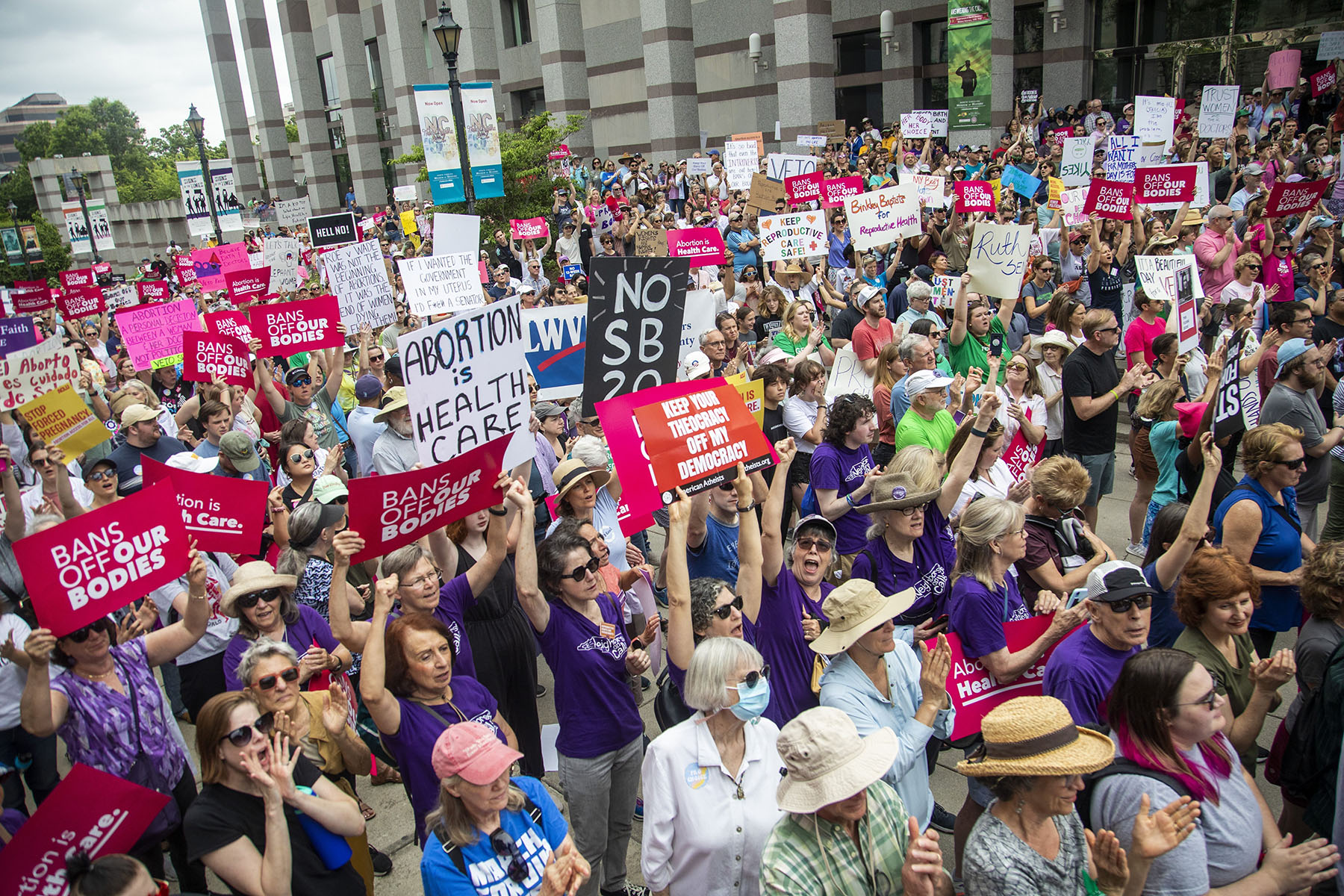 Abortion rights supporters watch North Carolina Gov. Roy Cooper sign a veto against the law that bans abortion after 1st trimester.