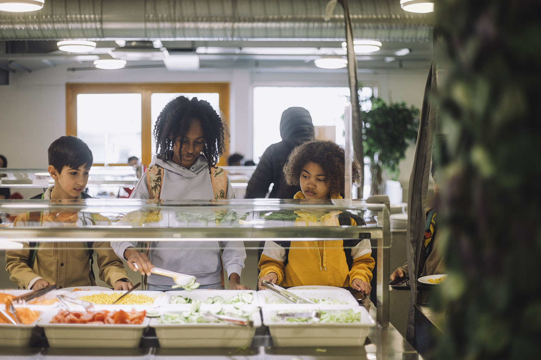 Friends choose their meal during lunch break in the cafeteria.