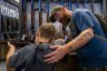 A father helps his son steady a firearm during the National Rifle Association's annual convention in May 2022 in Houston, Texas.