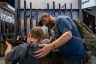 A father helps his son steady a firearm during the National Rifle Association's annual convention in May 2022 in Houston, Texas.