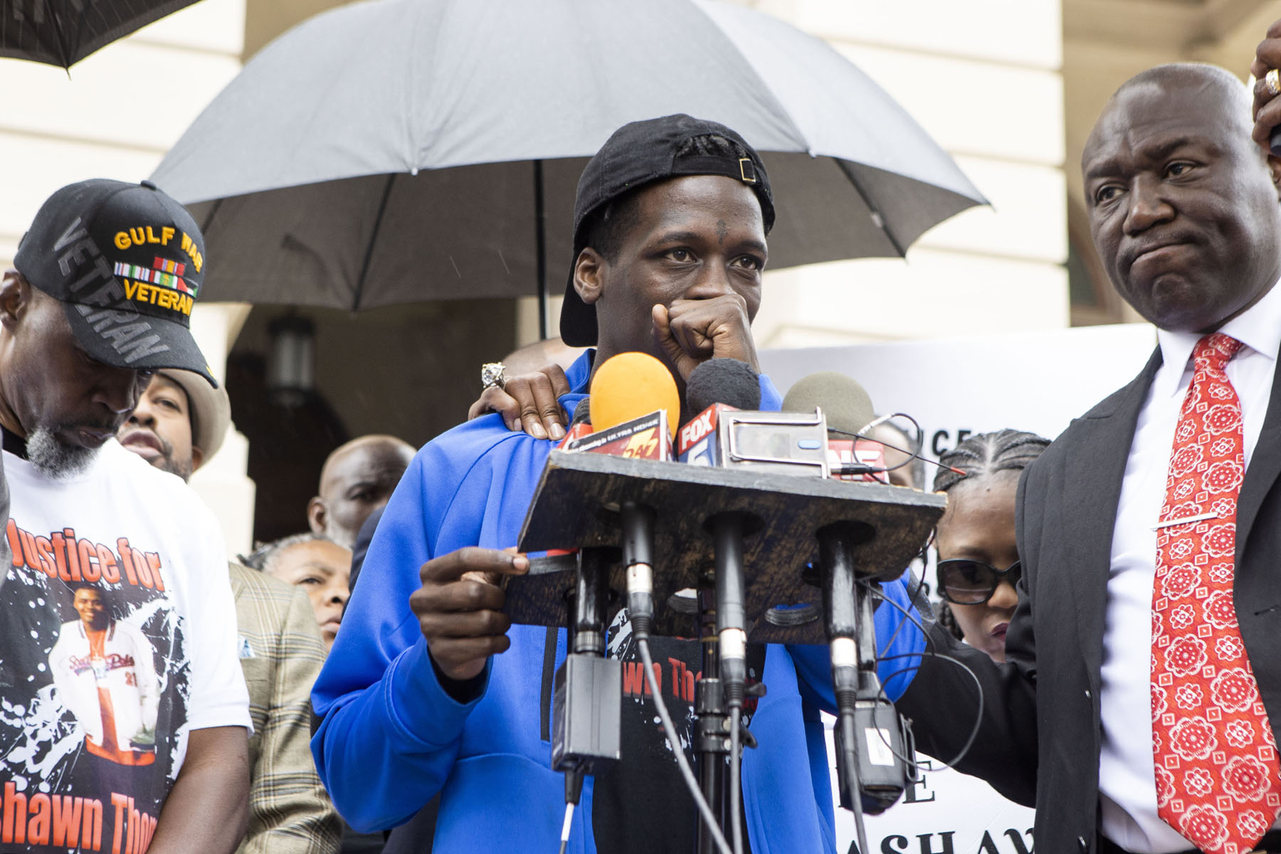 Brad McCrae, brother of Lashawn Thompson, sheds a tear while speaking at a press conference.