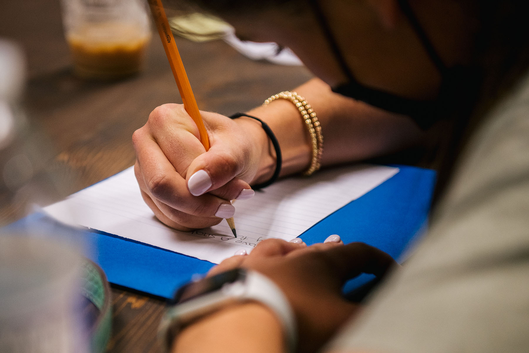 A student takes notes during a course in a classroom.