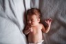 A close-up of a newborn baby lying on bed and sleeping.