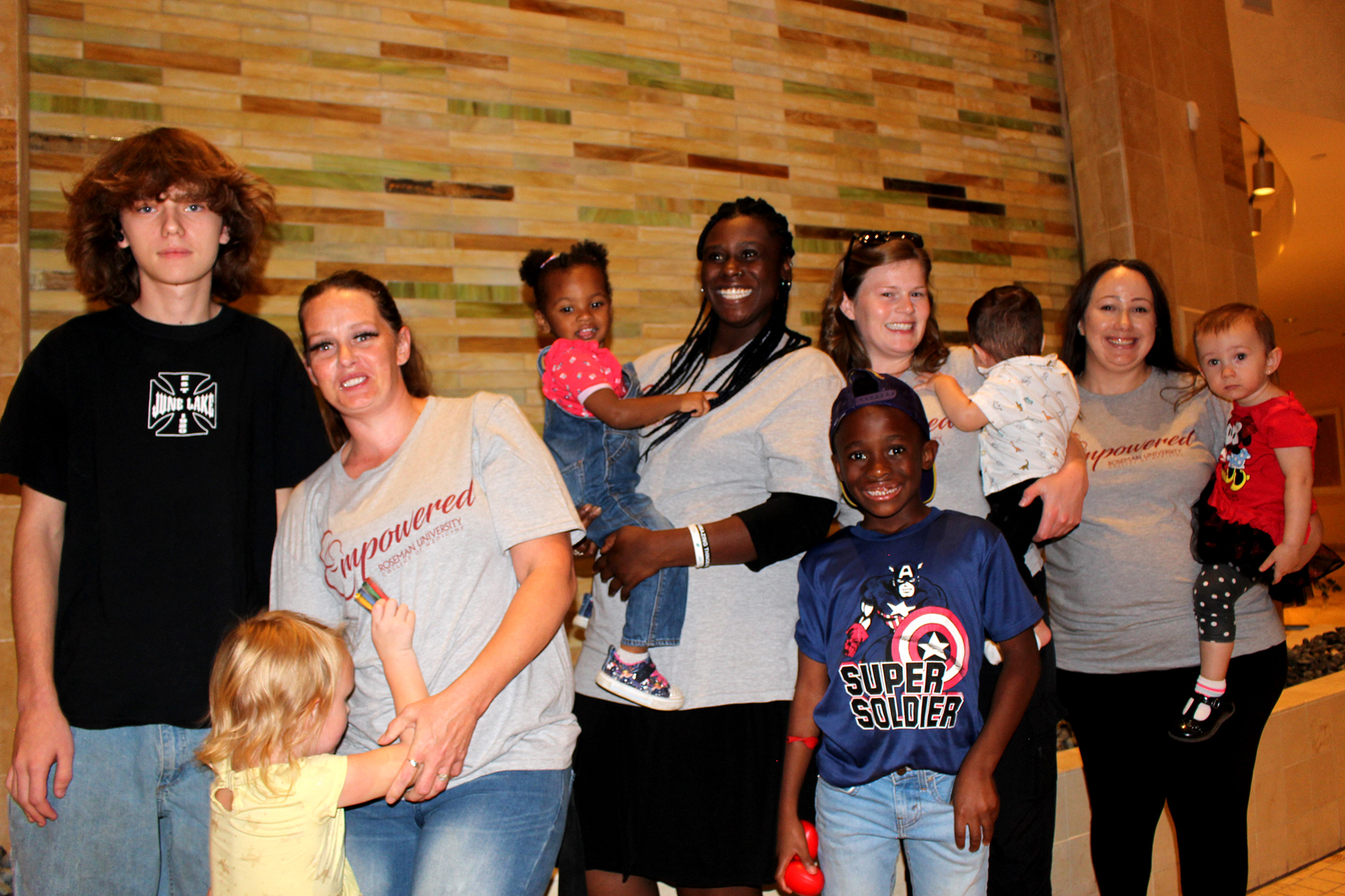 Amani and three other mothers pose together with their children after speaking on a panel about their experiences struggling with substance use while pregnant or postpartum.