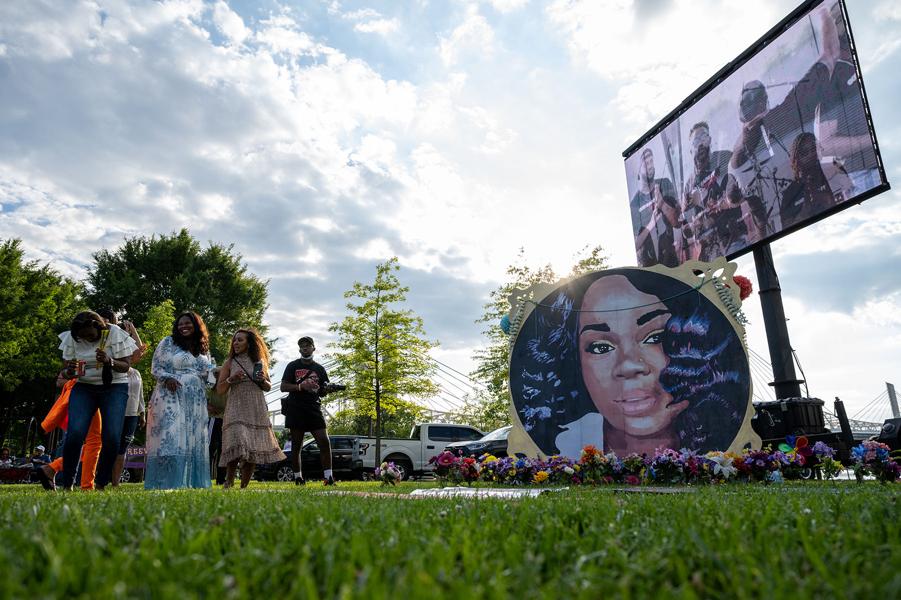 People stand near an art installation depicting Breonna Taylor at an event commemorating what would have been Breonna Taylor’s 28th birthday.