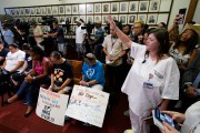 Advocates for cooling Texas prisons pray during a news conference at the Texas Capitol.