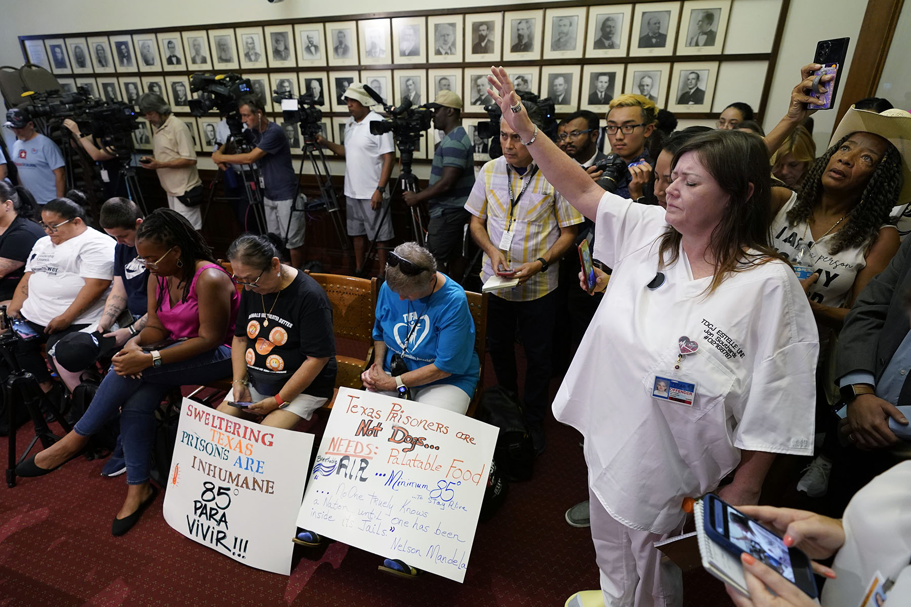 Advocates for cooling Texas prisons pray during a news conference at the Texas Capitol.