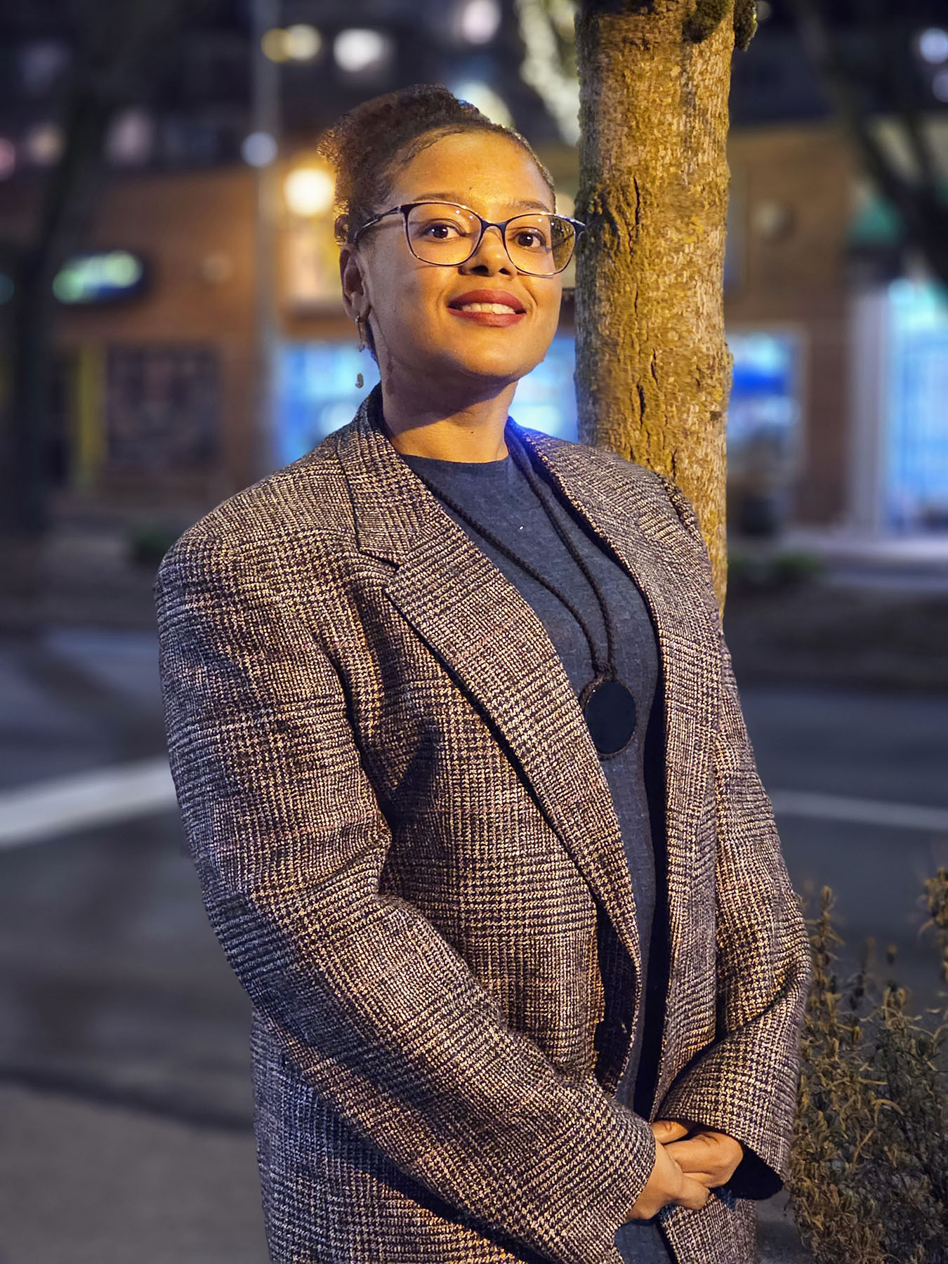 ChrisTiana ObeySumner smiles as she poses for a portrait at night.