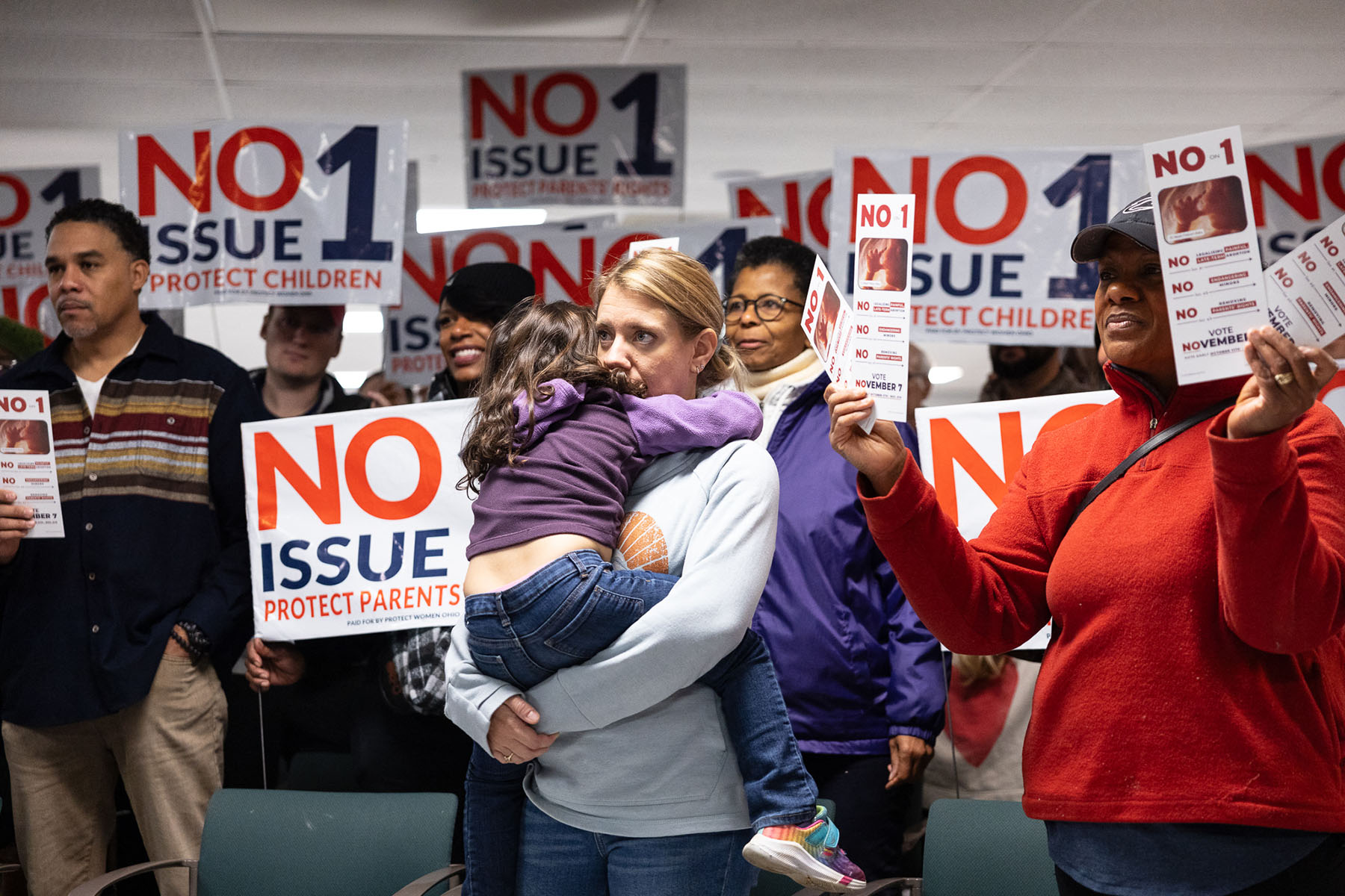 A woman is seen hugging a child as anti-abortion canvassers signs at Columbus Christian Center ahead of Election Day.