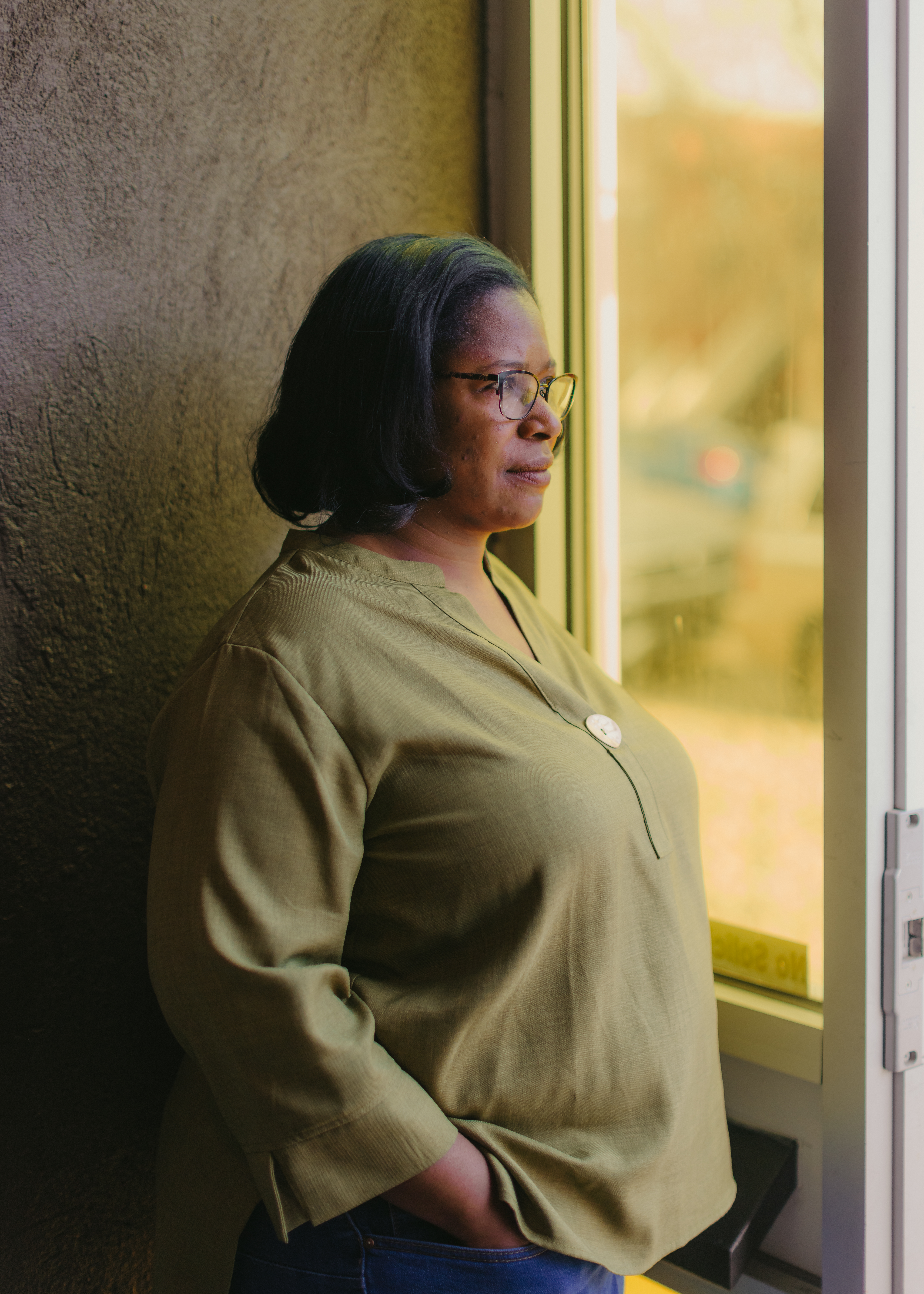 Kat Traylor looks out a window as she poses for a portrait in her Denver office space.