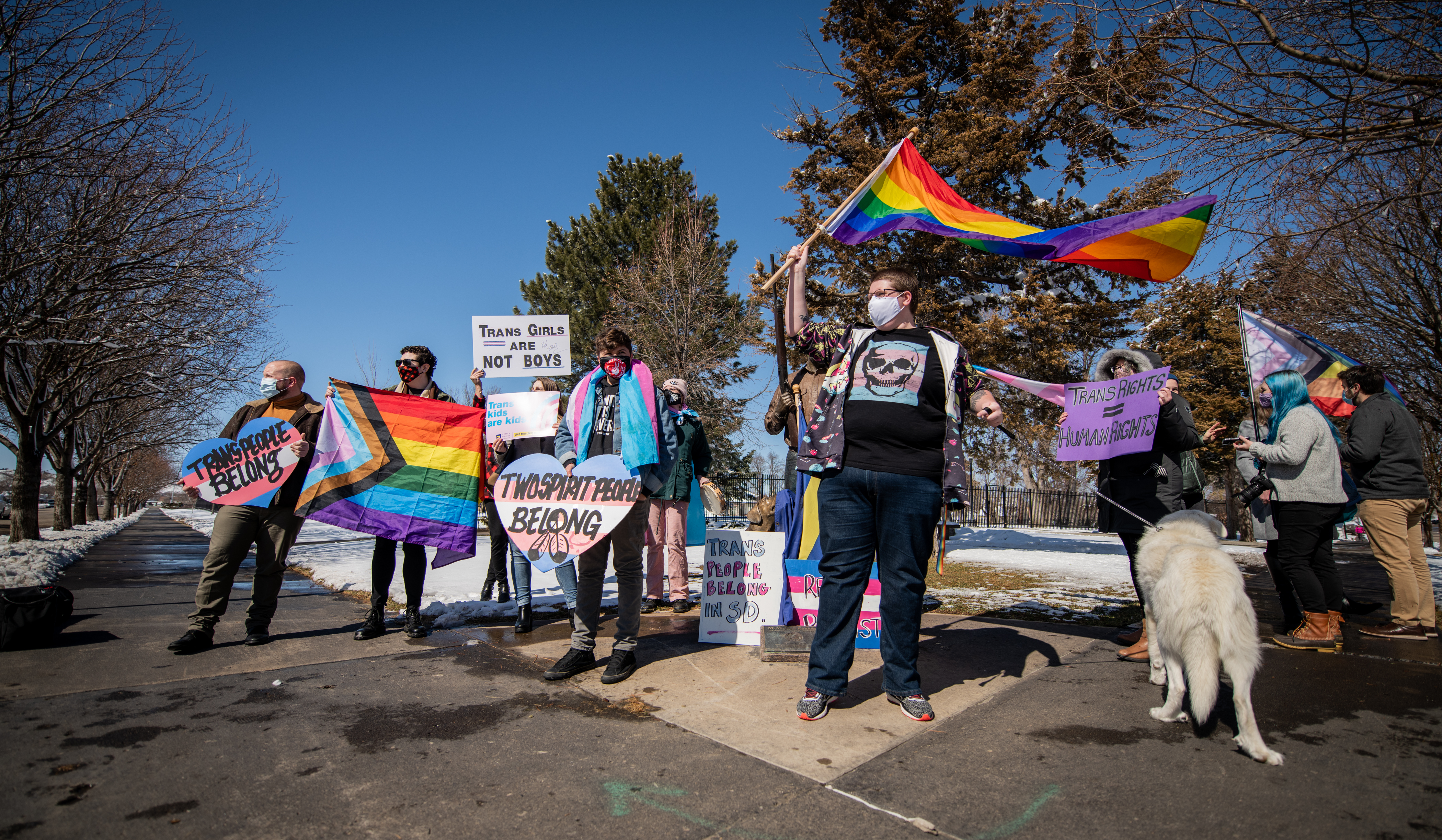 People waving flags and signs protest anti-trans bill in Pierre, South Dakota.