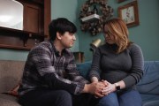 Ann Carver and her husband look at each other as they hold hands on their couch.