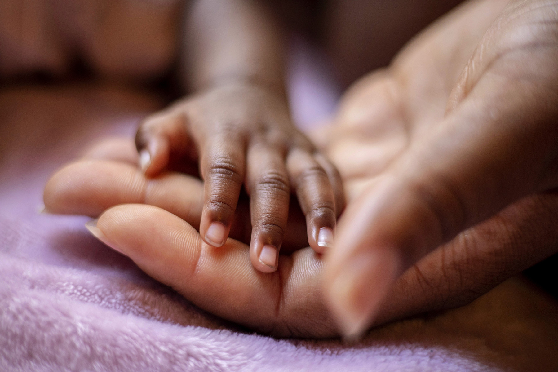 Journee' Divine Stokes rests her hand on her mother's while she sleeps.