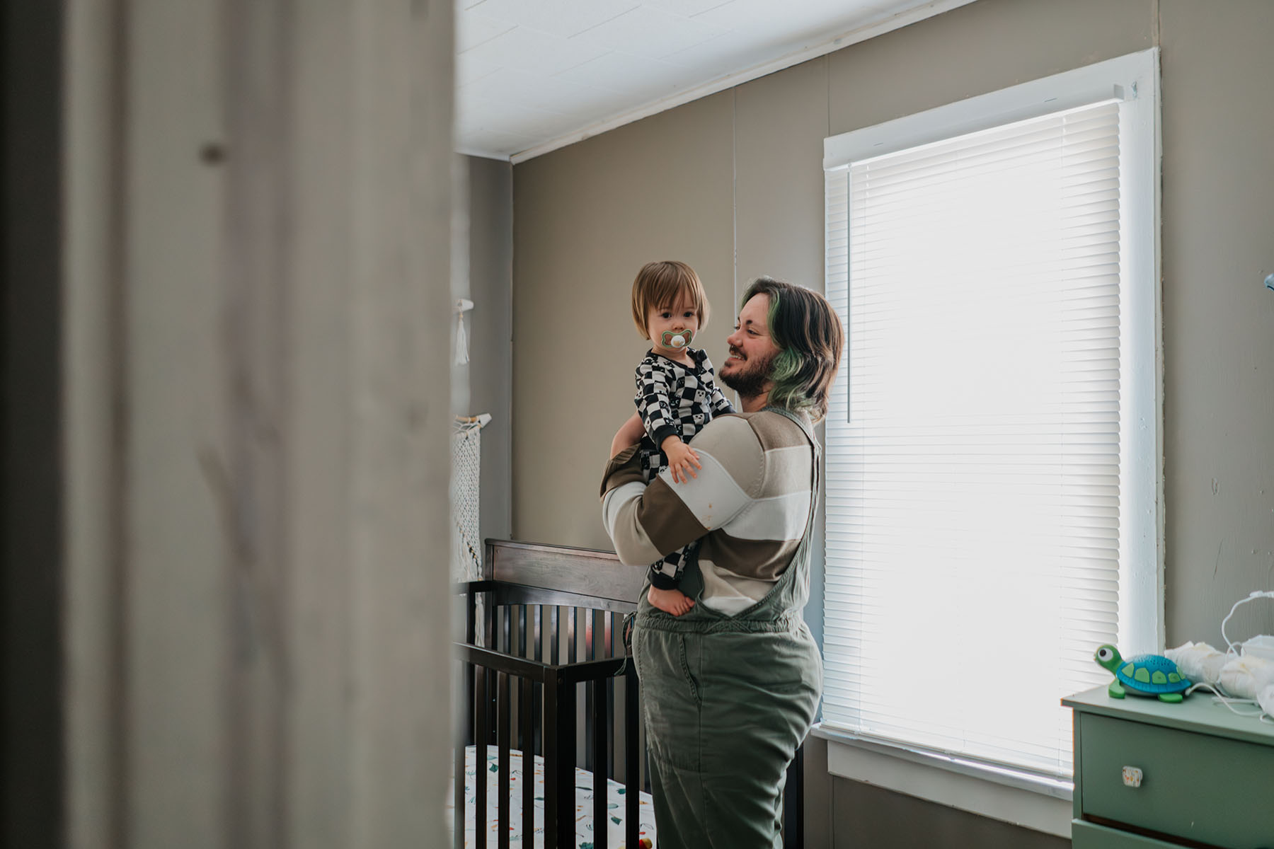 Sam Guido picks up their 16-month-old daughter after an afternoon nap.