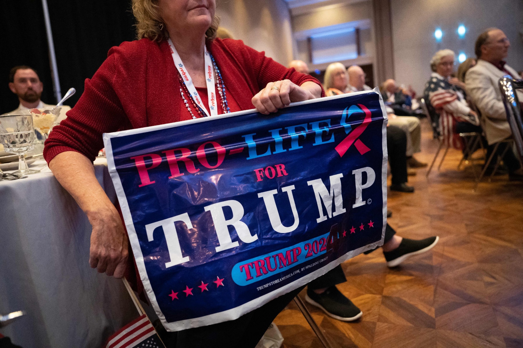 A woman in red shirt holds a sign that says "Pro-Life for Trump"