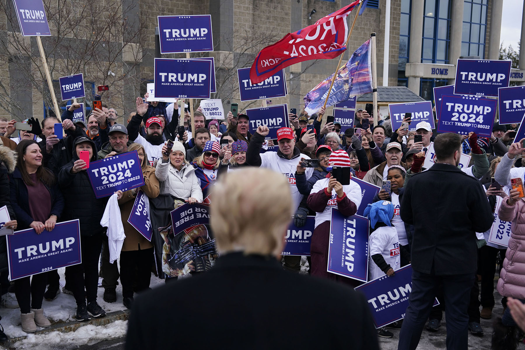 Former president Donald Trump greets supporters outside a polling location at a high school in Londonderry, New Hampshire.