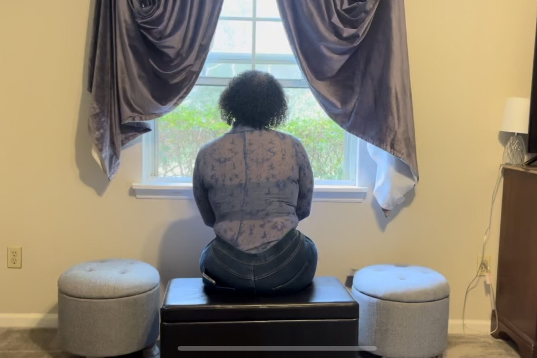 Jae Cancel sits at the window inside a Tallahassee, Florida, transgender safe house.