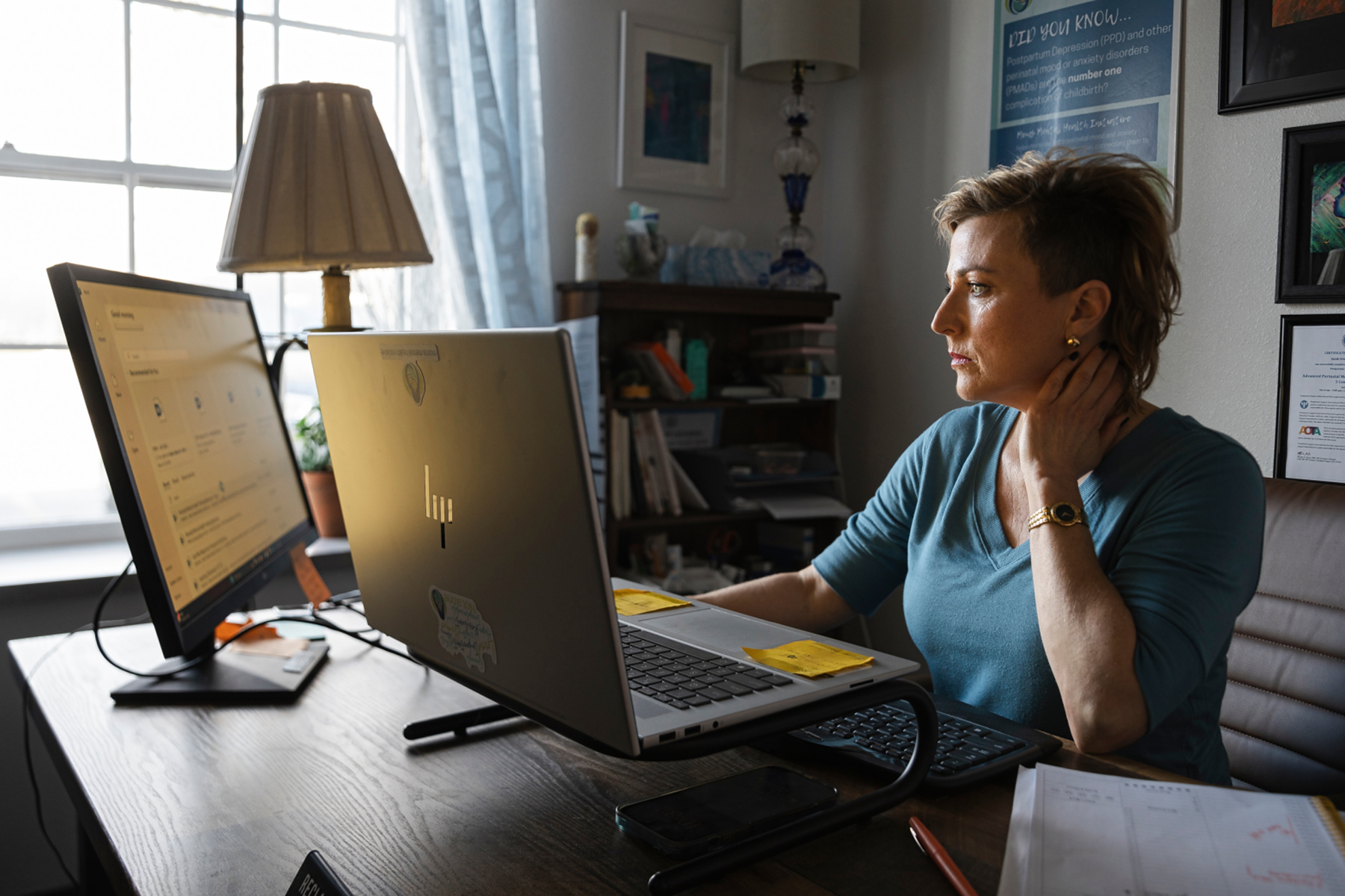 Portrait of Sarah Bloomquist working at her computer in her office.