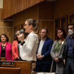 Arizona state Sen. Eva Burch stands up and speaks into a microphone on the floor, surrounded by other Democratic senators