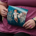 close-up photo of a seated woman holding a photograph of her baby, who was conceived through IVF