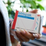 A woman holds a pack of pills used for abortions.