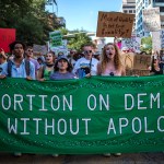 Protesters march while holding signs during an abortion-rights rally in Austin, Texas.