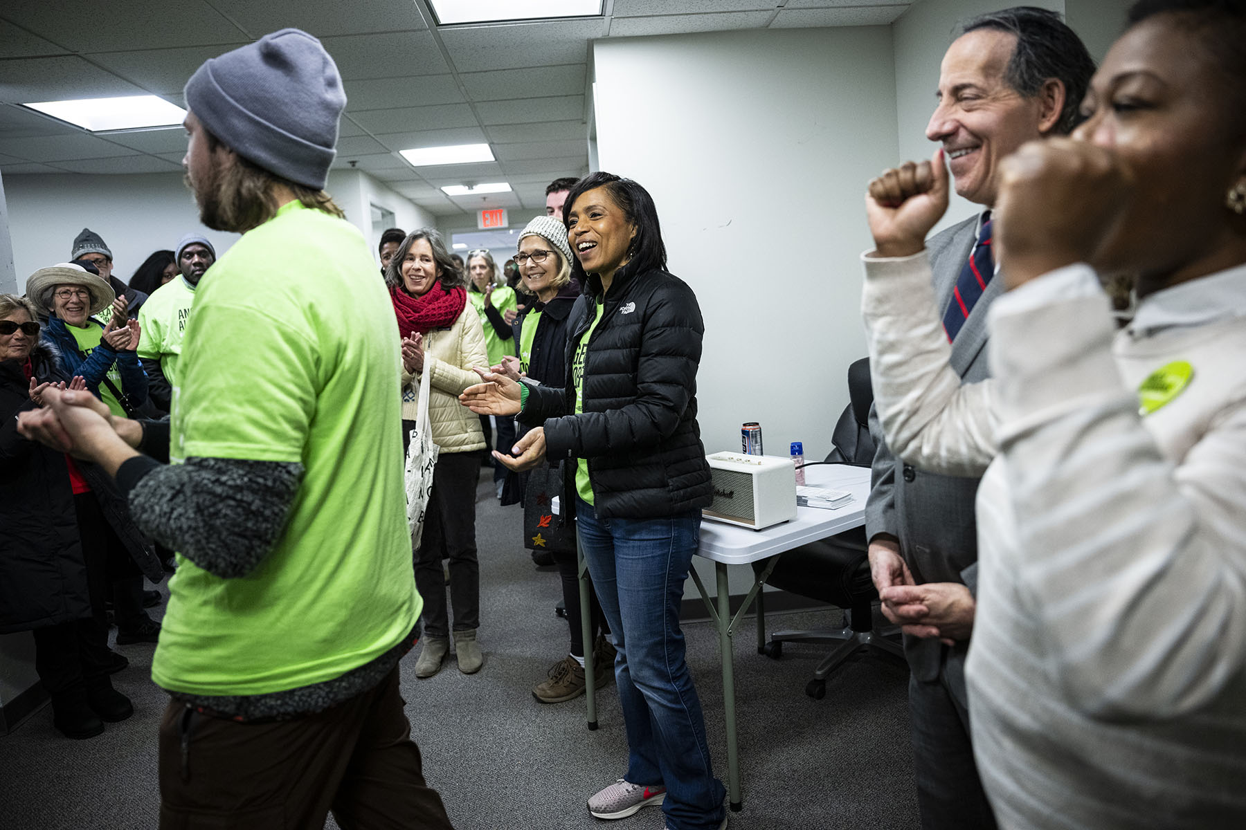 Angela Alsobrooks smiles and claps as a campaign worker speaks during an event at the Alsobrooks for Senate Montgomery County field office.