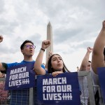 Demonstrators hold their fists up as they chant during a March for Our Lives rally against gun violence on the National Mall.