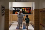 A teachers leads her student to English class at an elementary school.