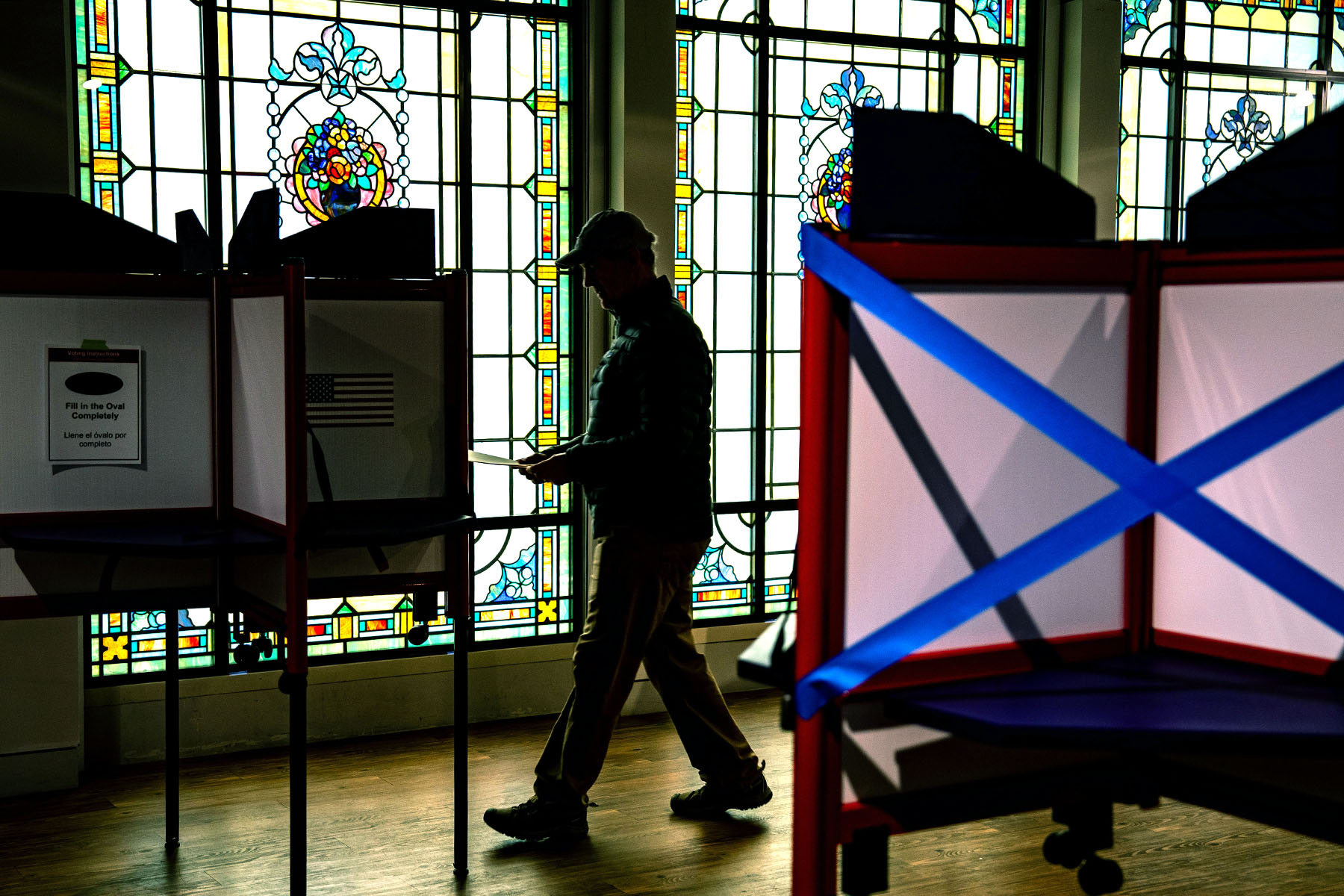 A silhouetted voter casts their ballots at a polling location in Arlington, Virginia.