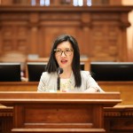 Rep. Michelle Au speaks at a podium.