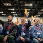 Three men raise their ballots during a Southern Baptist Convention annual meeting.