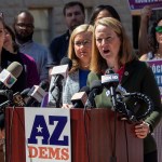 Arizona Attorney General Kris Mayes speaks at a podium during a press briefing.