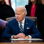 President Joe Biden signs a presidential memorandum in the Oval Office at the White House.