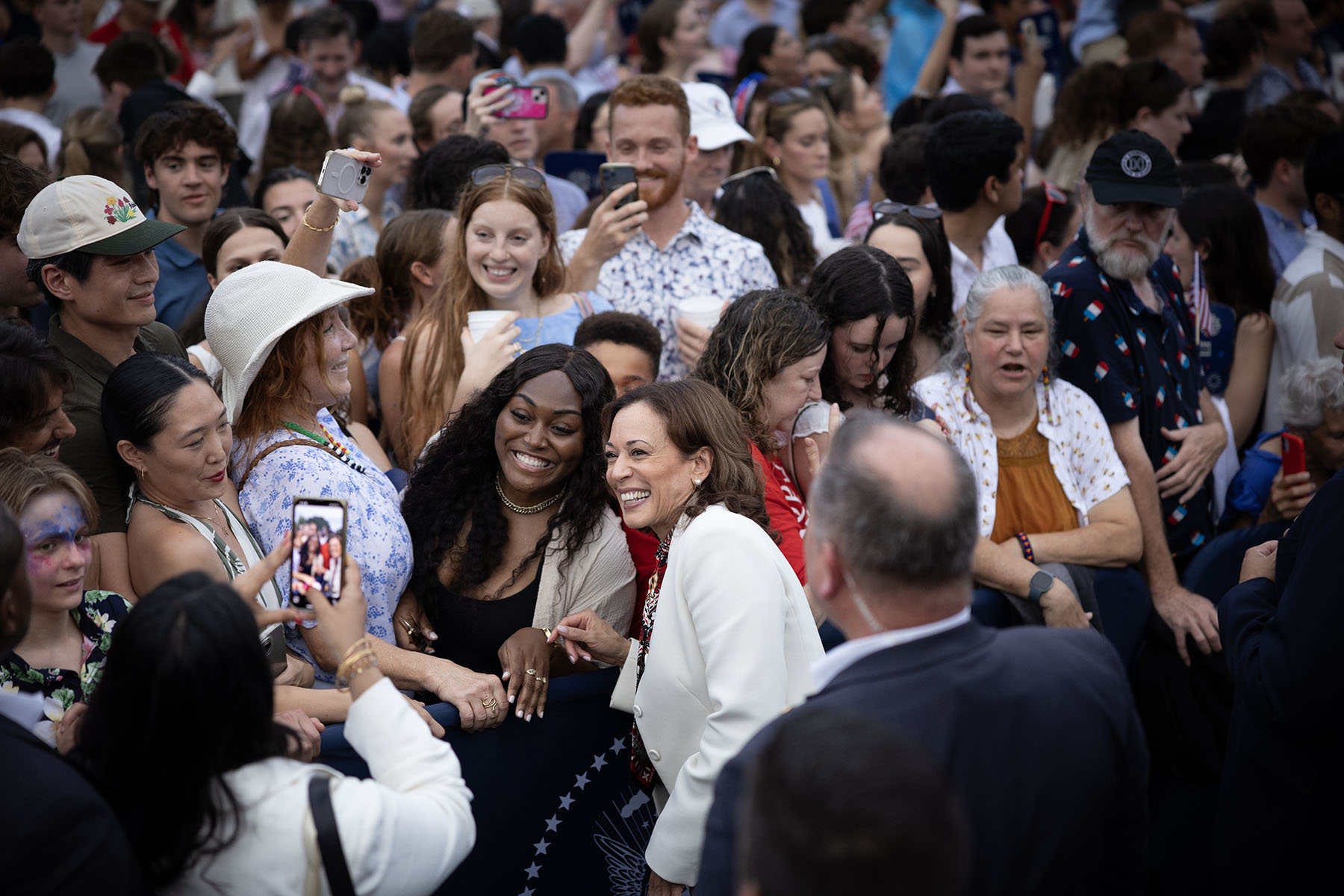 Vice President Kamala Harris takes selfies with audience members during an Independence Day celebration at the White House.