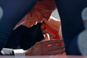 Secret Service tend to republican former President Donald Trump onstage at a rally. Blood is seen on the former president's face.