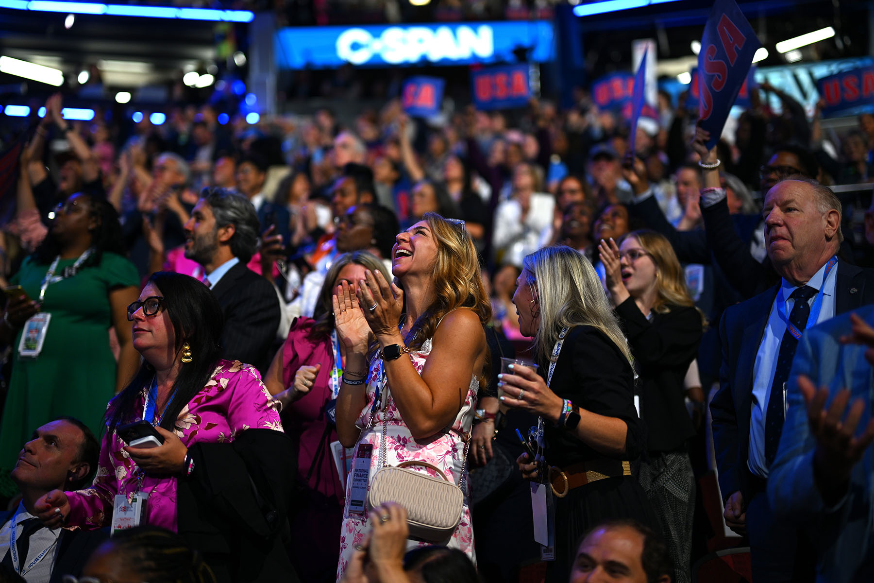 Attendees cheer as talk show host Oprah Winfrey speaks on stage during the third day of the DNC.