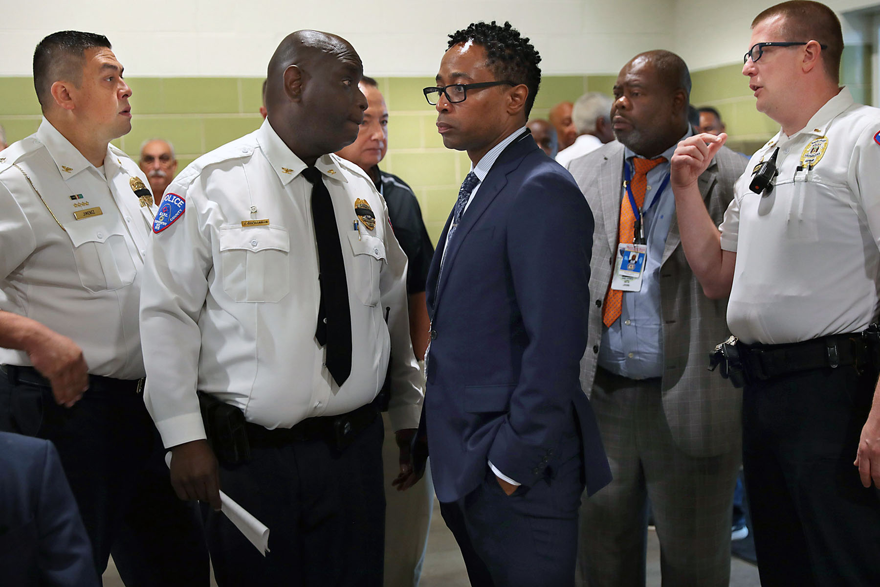 Wesley Bell is surrounded by area police chiefs before a news conference.