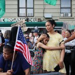 A woman holds a young girl as People gather to protest a campaign event for Democratic presidential candidate Vice President Kamala Harris in New York City.