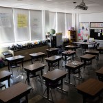 Desks are seen in an empty elementary school classroom.