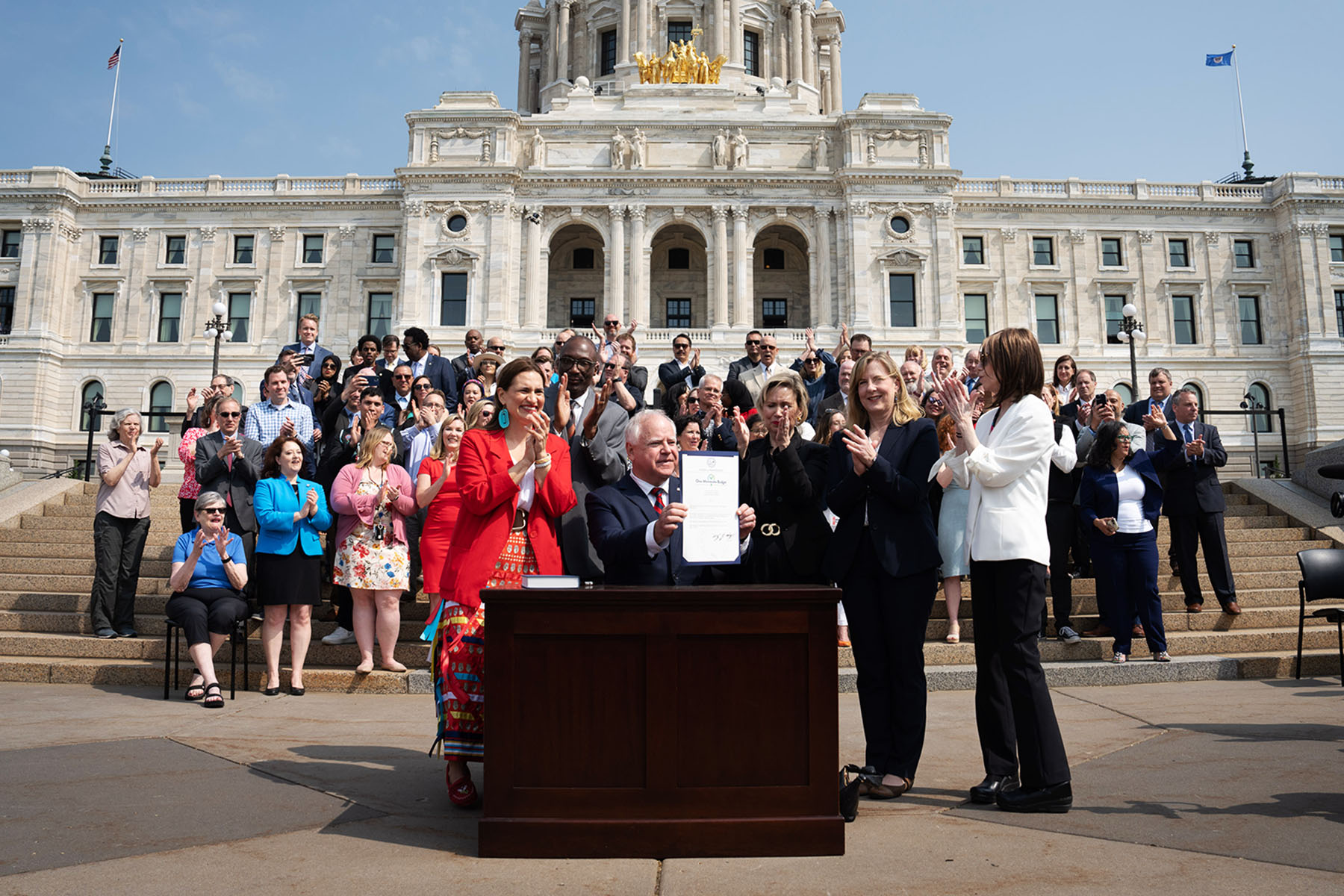 Gov. Tim Walz is seen at a ceremonial budget bill-signing party on the Minnesota State Capitol steps.