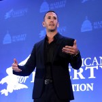 Corey DeAngelis speaks on stage at an event.