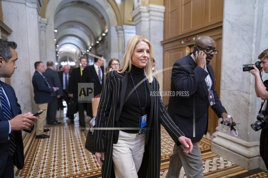 Pam Bondi walks down the hall.