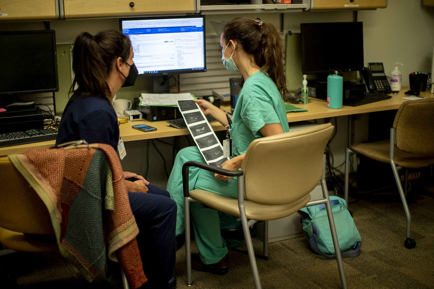 A family physician and her resident look over an ultrasound at a reproductive health clinic